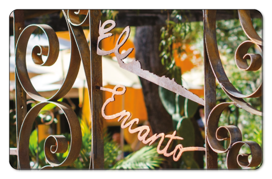 Image of a wrought iron fence with El Encanto welded into it.